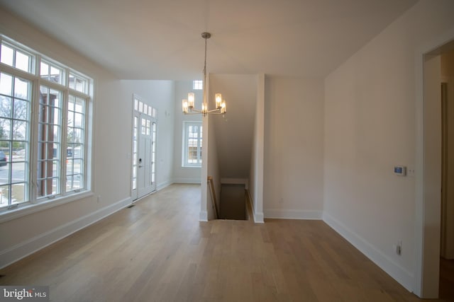 unfurnished dining area with a notable chandelier and hardwood / wood-style floors