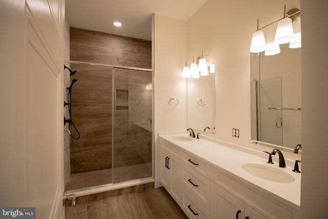 bathroom with hardwood / wood-style flooring, vanity, and a shower with shower door