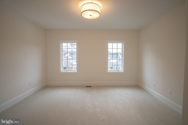 carpeted empty room with plenty of natural light