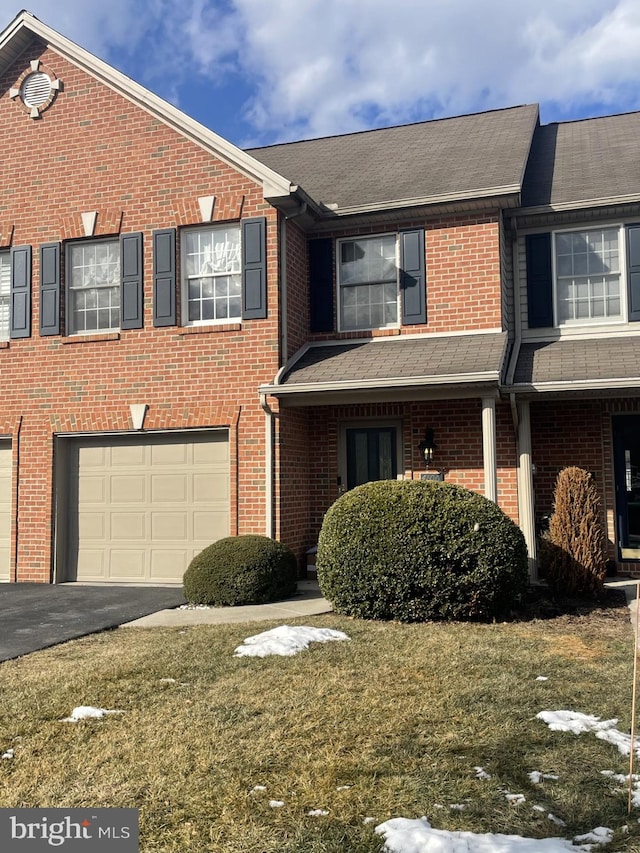 multi unit property featuring a garage and a front yard