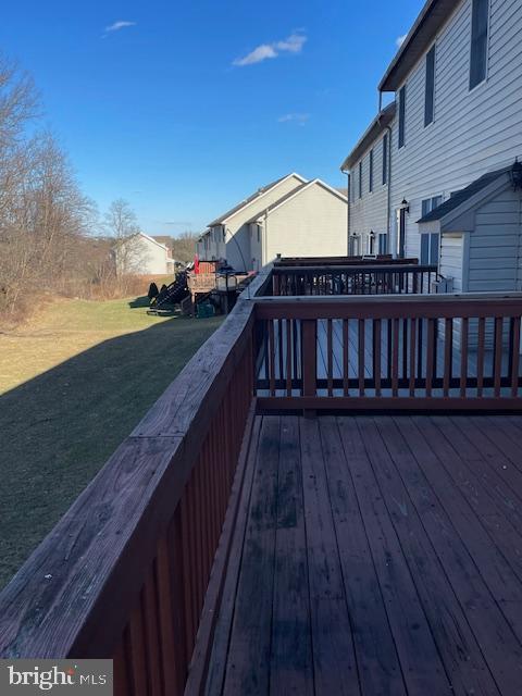 wooden deck featuring a lawn