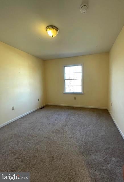 empty room featuring dark carpet