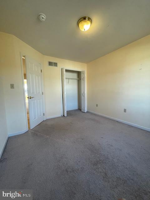 unfurnished bedroom with carpet and a closet