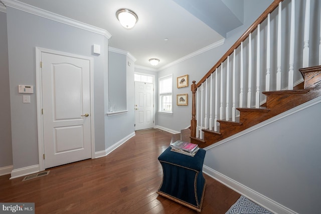 foyer entrance with crown molding and dark wood-type flooring