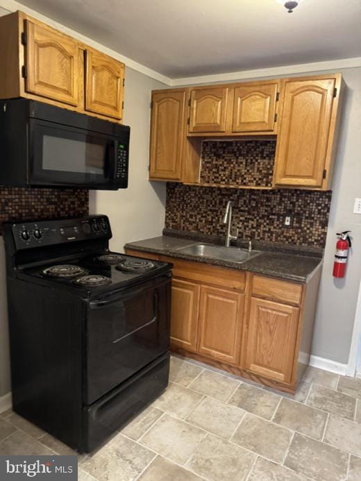 kitchen featuring sink, decorative backsplash, and black appliances