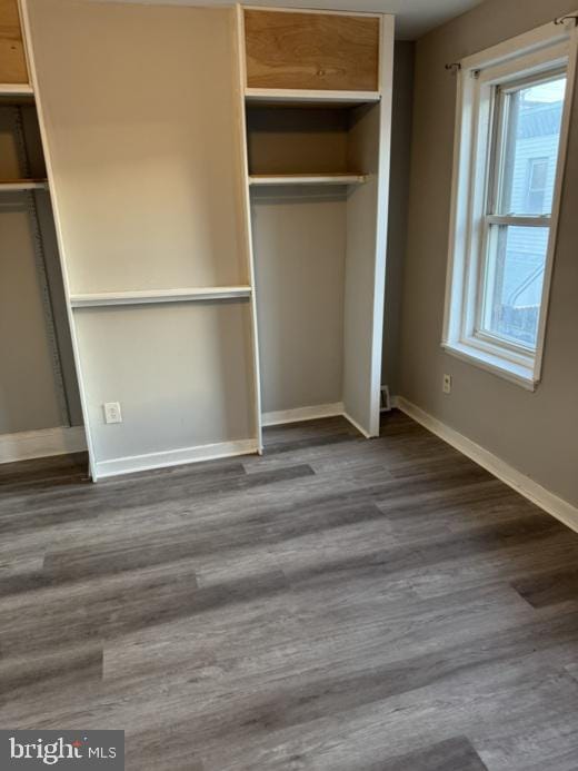 unfurnished bedroom featuring dark hardwood / wood-style flooring and a closet