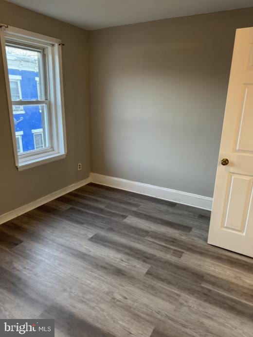 unfurnished room featuring dark hardwood / wood-style flooring