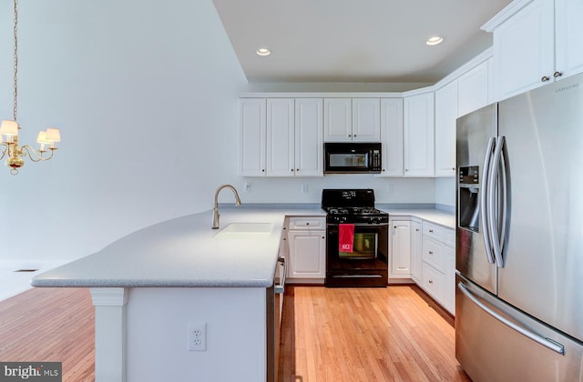 kitchen featuring sink, white cabinetry, decorative light fixtures, light hardwood / wood-style floors, and black appliances