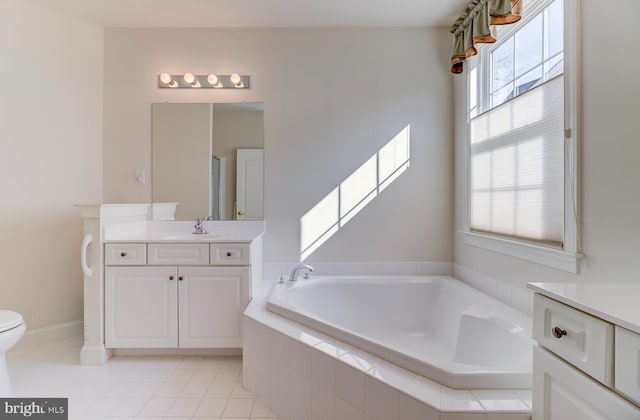 bathroom featuring tiled tub, vanity, tile patterned flooring, and toilet