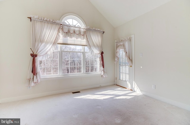 carpeted empty room featuring high vaulted ceiling