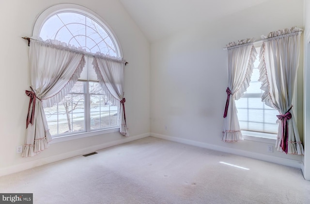 carpeted spare room with lofted ceiling