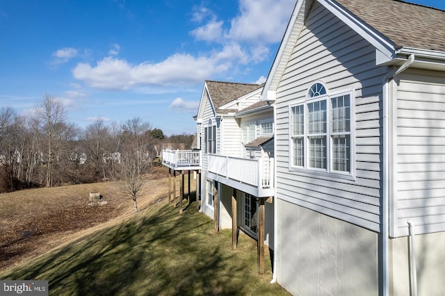 view of side of home featuring a yard and a deck