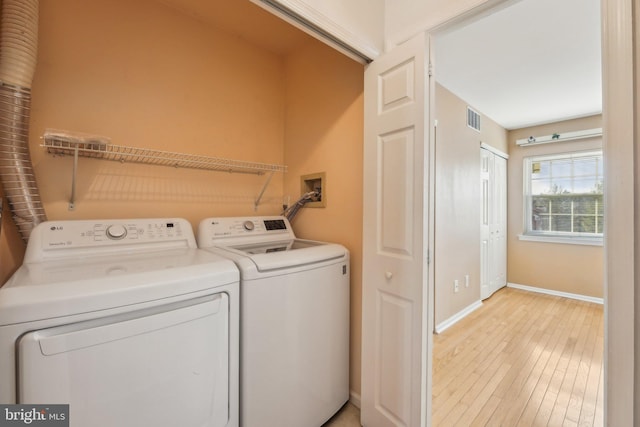 washroom featuring light hardwood / wood-style flooring and washer and dryer