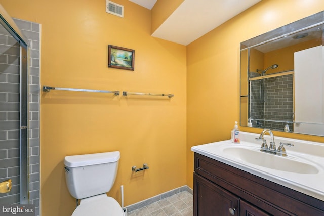 bathroom featuring tiled shower, vanity, and toilet