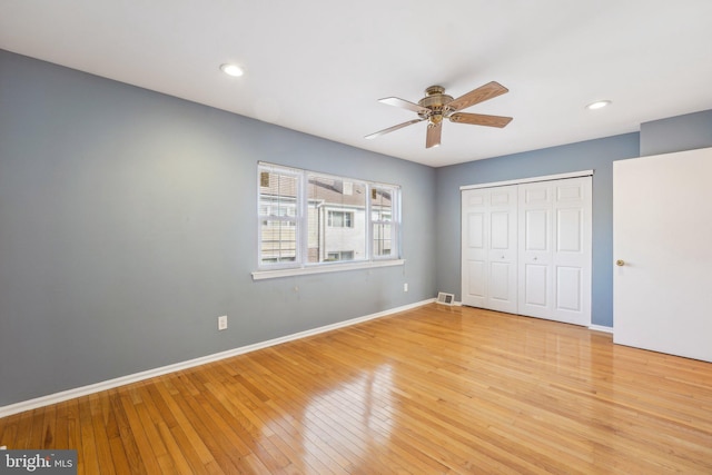 unfurnished bedroom featuring ceiling fan, a closet, and light hardwood / wood-style flooring