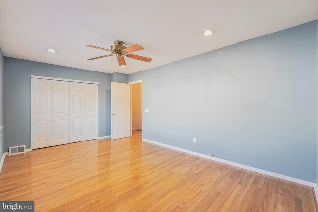 unfurnished bedroom with ceiling fan, light hardwood / wood-style floors, and a closet