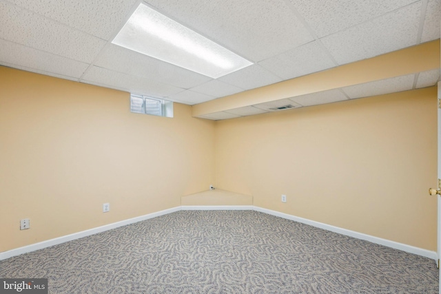 basement with carpet flooring and a paneled ceiling