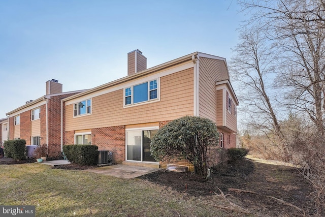 back of house featuring a yard, central AC, and a patio area