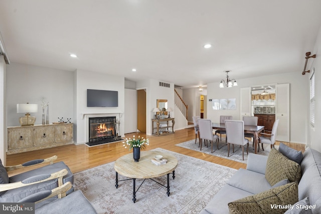 living room with a chandelier and light hardwood / wood-style flooring