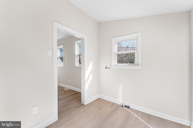 laundry room with a healthy amount of sunlight, washer hookup, and light hardwood / wood-style flooring