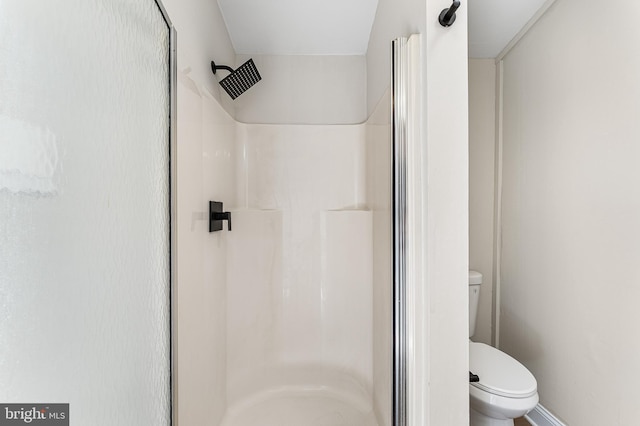 bathroom featuring walk in shower and toilet