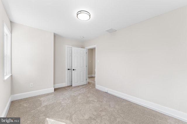 empty room featuring light carpet