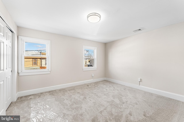 carpeted spare room featuring a healthy amount of sunlight