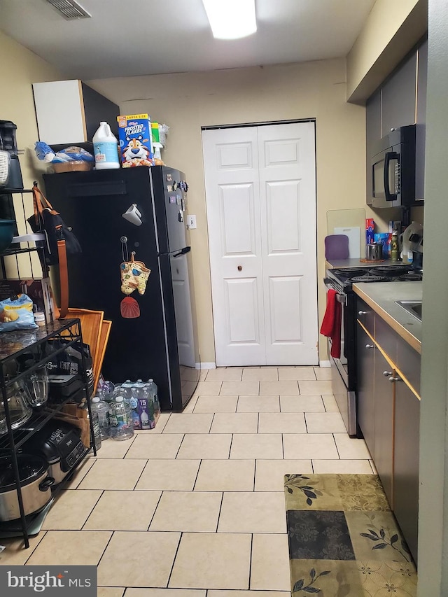 kitchen with light tile patterned floors and black appliances