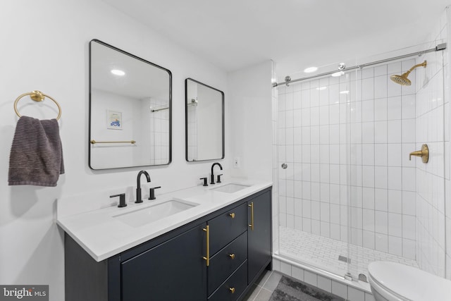 bathroom with tile patterned floors, vanity, toilet, and a tile shower