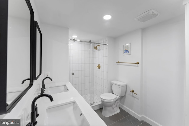 bathroom with tile patterned flooring, sink, a tile shower, and toilet