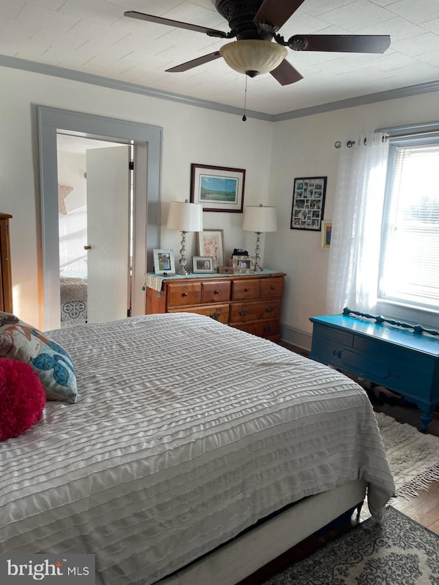 bedroom featuring crown molding, wood-type flooring, and ceiling fan