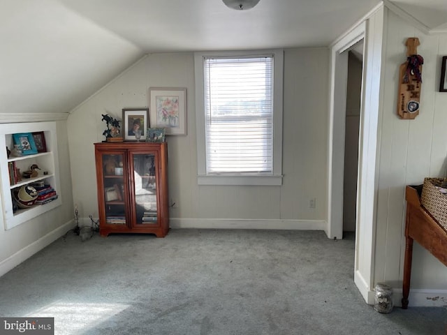 bonus room with lofted ceiling and light colored carpet