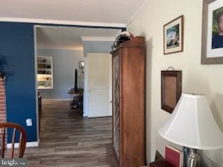 hallway with dark hardwood / wood-style flooring and ornamental molding