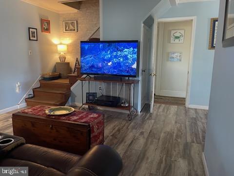 living room with hardwood / wood-style flooring and ornamental molding