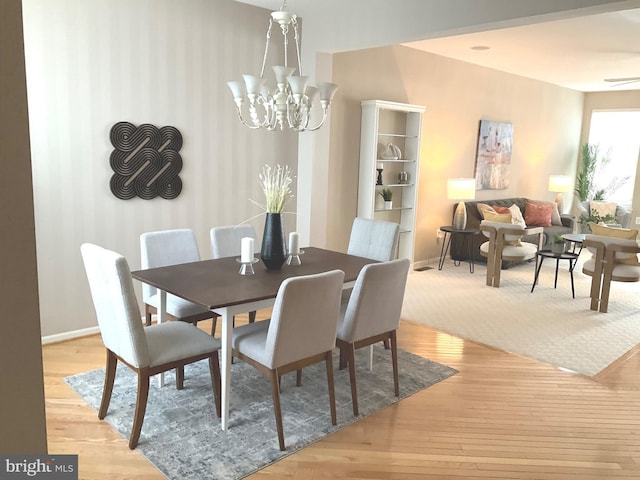 dining room with an inviting chandelier and light hardwood / wood-style floors