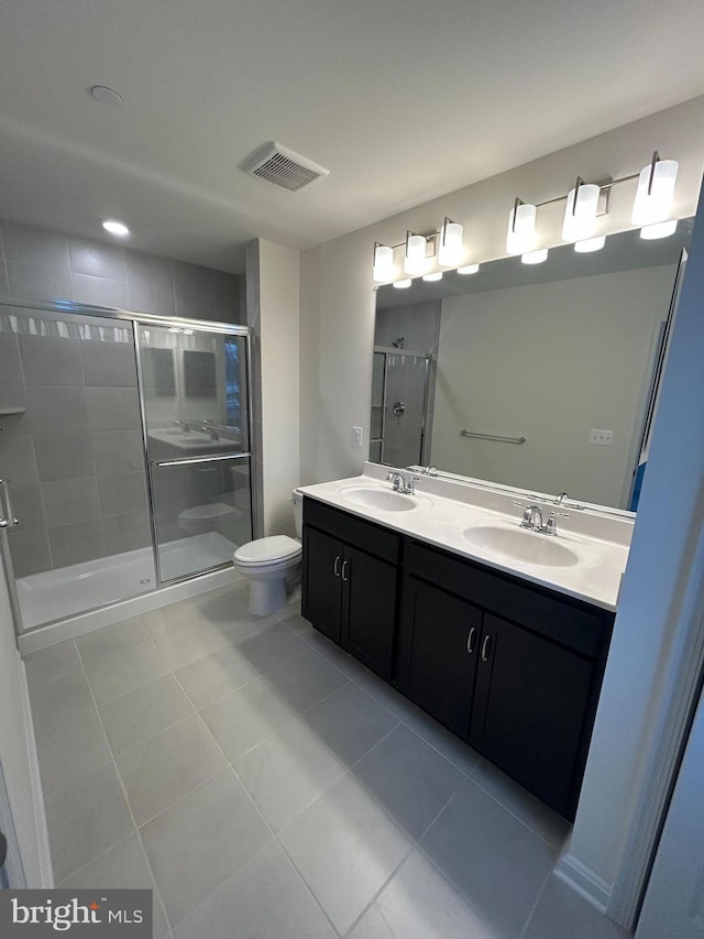 bathroom with vanity, toilet, tile patterned floors, and walk in shower