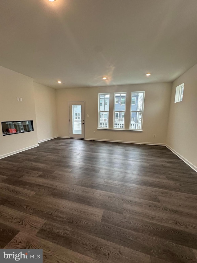 unfurnished living room featuring dark wood-type flooring