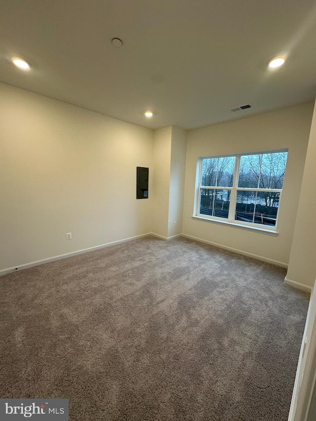 empty room with electric panel and carpet flooring