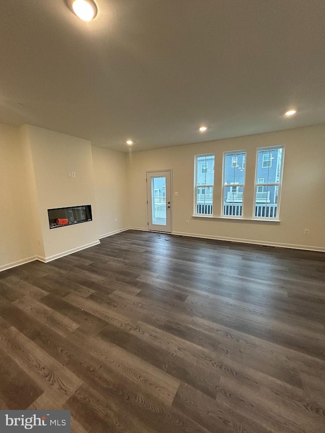 unfurnished living room with dark hardwood / wood-style floors