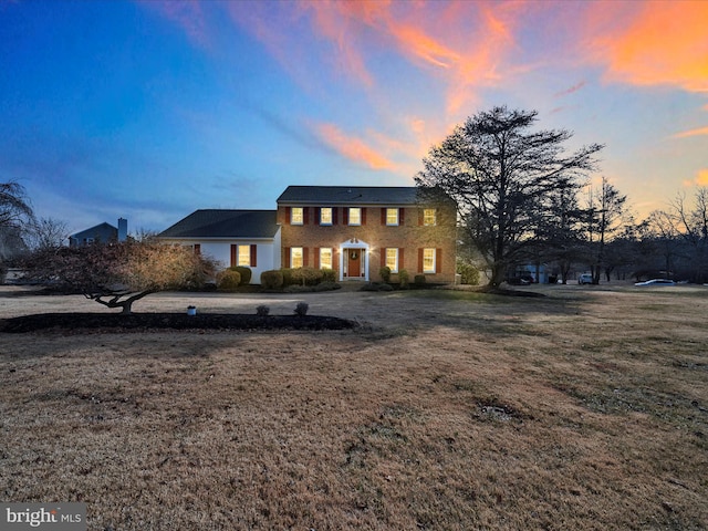 colonial inspired home with a lawn