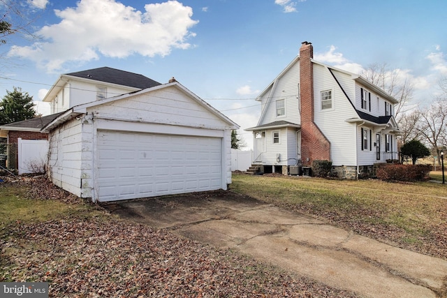 view of side of home with a garage, a yard, and central AC