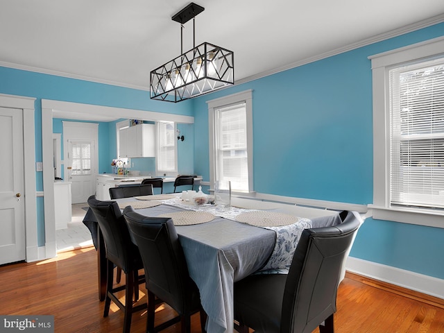 dining area featuring ornamental molding, hardwood / wood-style floors, and an inviting chandelier