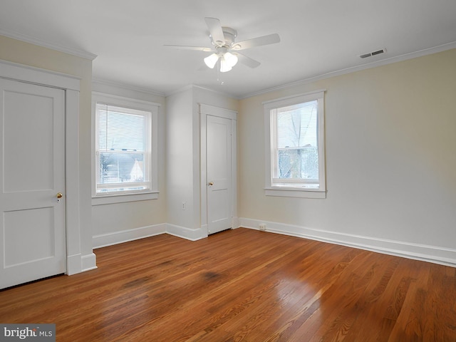 unfurnished bedroom featuring crown molding, wood-type flooring, and ceiling fan