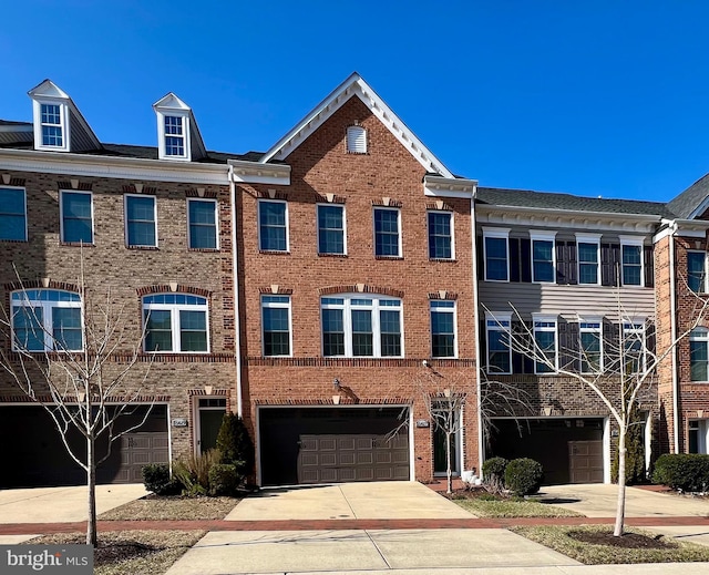 multi unit property featuring concrete driveway, brick siding, and an attached garage