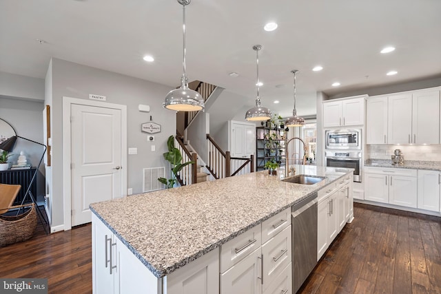 kitchen with tasteful backsplash, visible vents, dark wood-type flooring, stainless steel appliances, and a sink