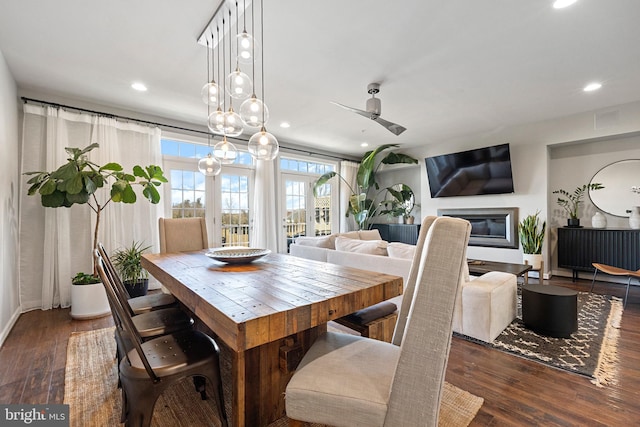 dining space featuring ceiling fan, hardwood / wood-style floors, a glass covered fireplace, and recessed lighting