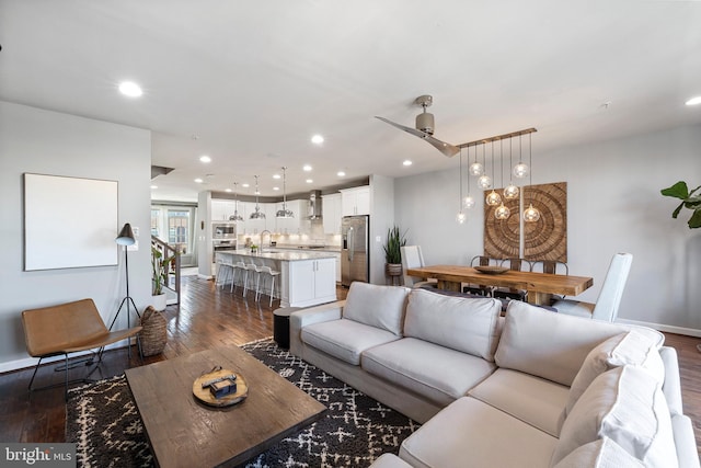 living area with dark wood-style floors, ceiling fan, baseboards, and recessed lighting