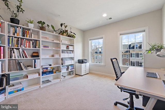 carpeted home office featuring visible vents and baseboards