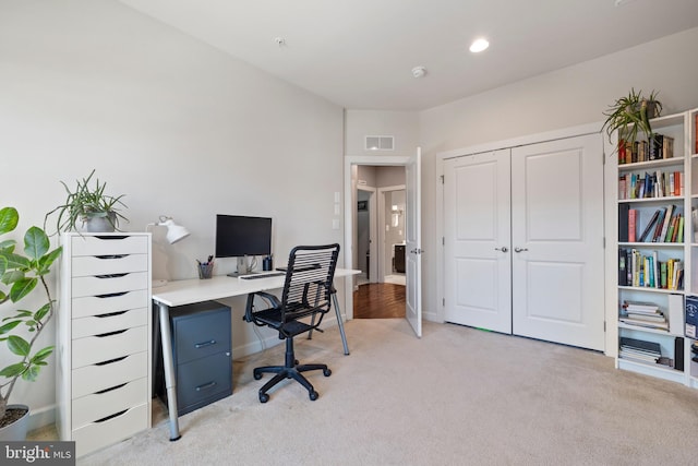 office area with light colored carpet, visible vents, and baseboards