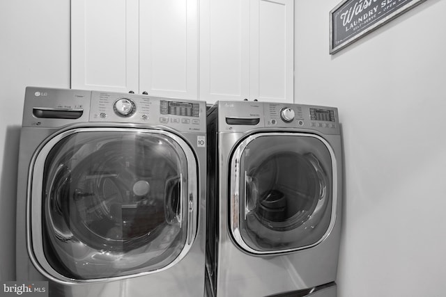 washroom featuring cabinet space and separate washer and dryer